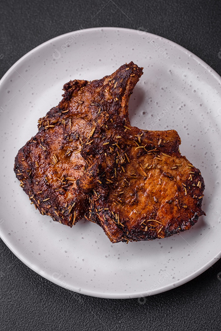 Deliciosas pernas de frango grelhado com especiarias e ervas em molho teriyaki sobre um fundo escuro de concreto