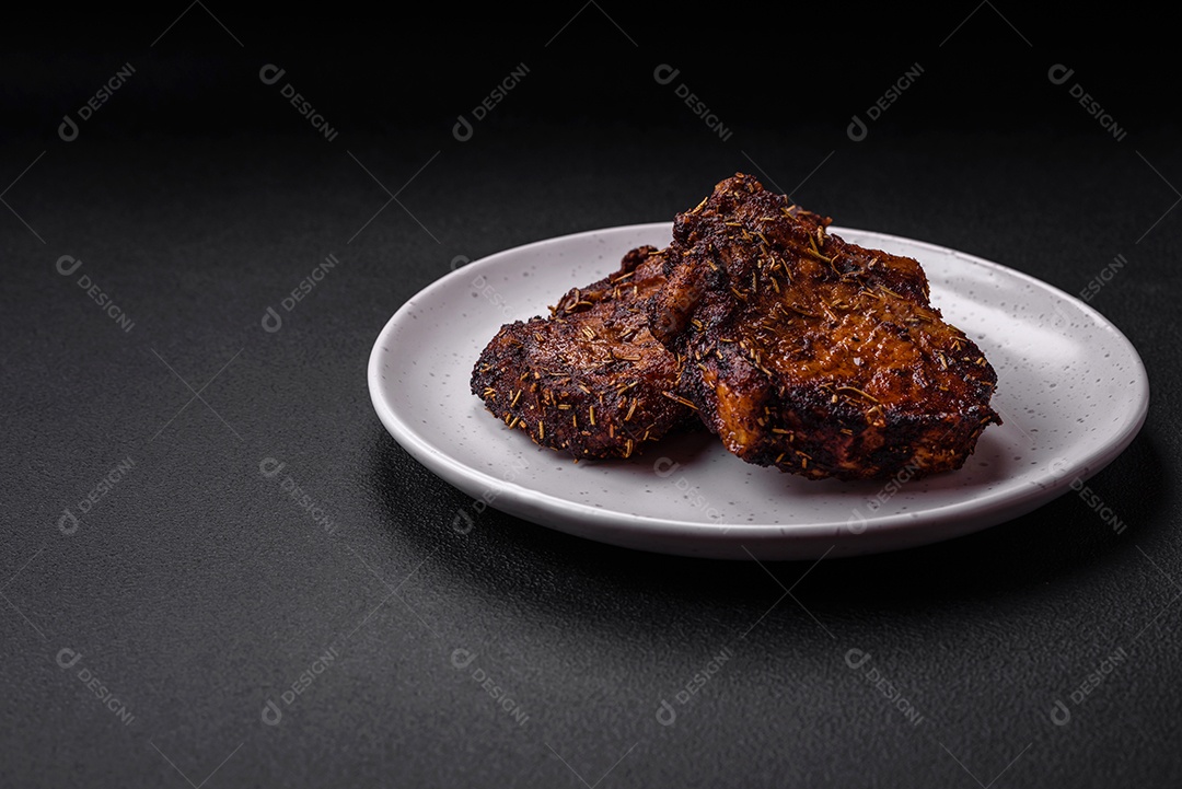 Deliciosas pernas de frango grelhado com especiarias e ervas em molho teriyaki sobre um fundo escuro de concreto