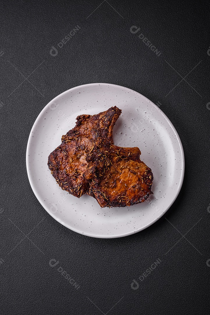 Deliciosas pernas de frango grelhado com especiarias e ervas em molho teriyaki sobre um fundo escuro de concreto