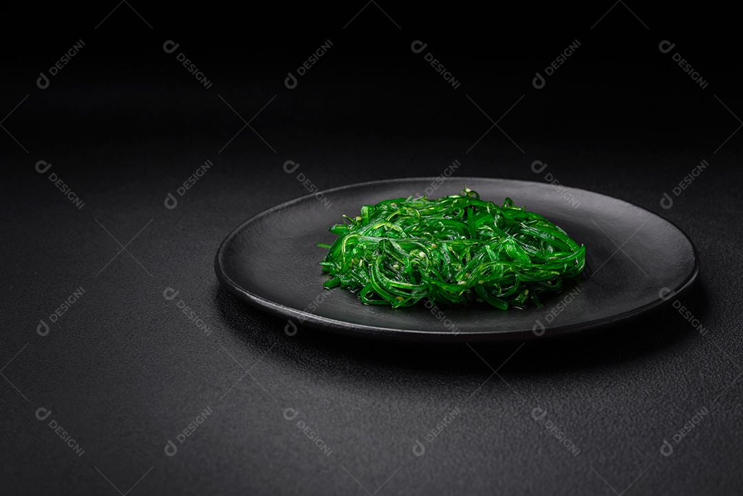 Deliciosa salada de frutos do mar hiashi wakume vegetariana saudável com sementes de gergelim em um fundo escuro de concreto