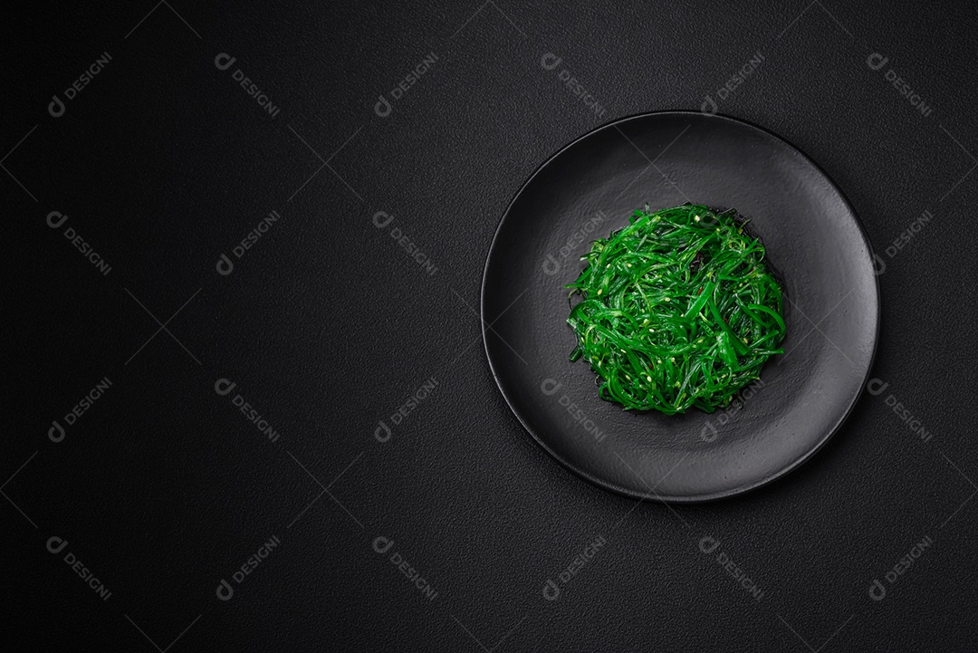 Deliciosa salada de frutos do mar hiashi wakume vegetariana saudável com sementes de gergelim em um fundo escuro de concreto