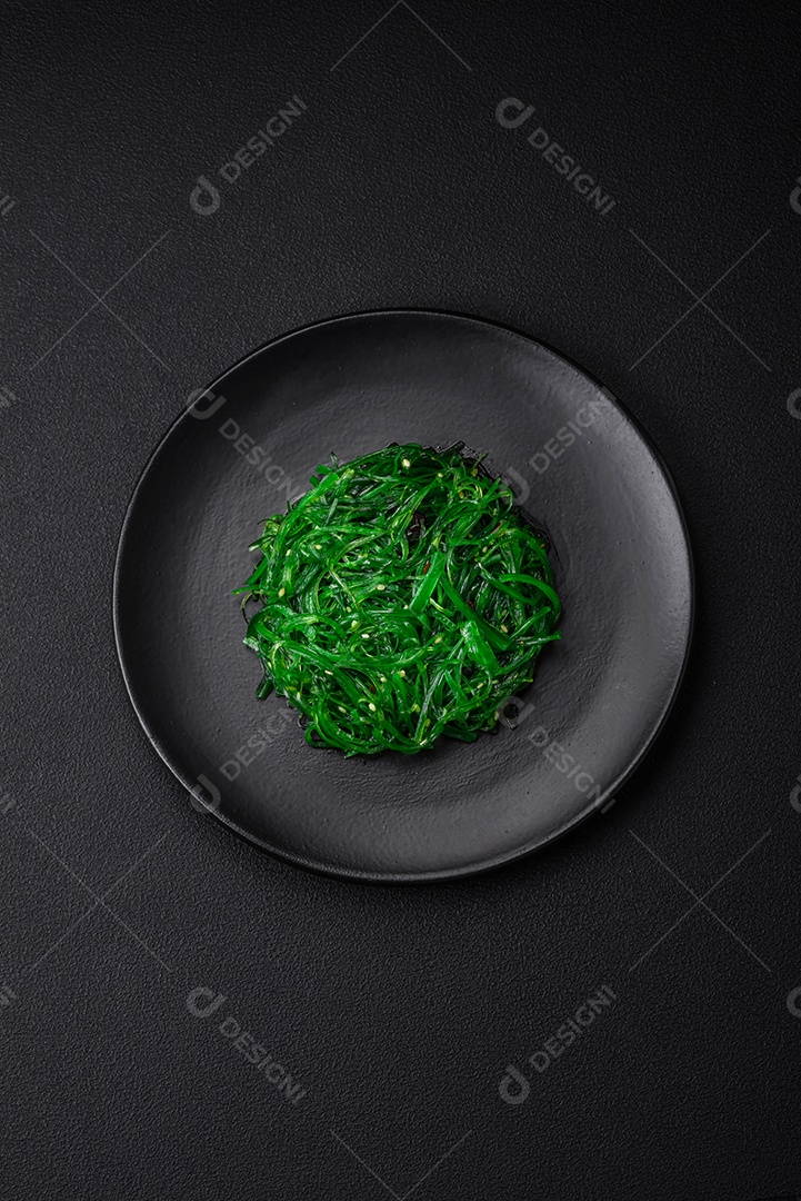 Deliciosa salada de frutos do mar hiashi wakume vegetariana saudável com sementes de gergelim em um fundo escuro de concreto