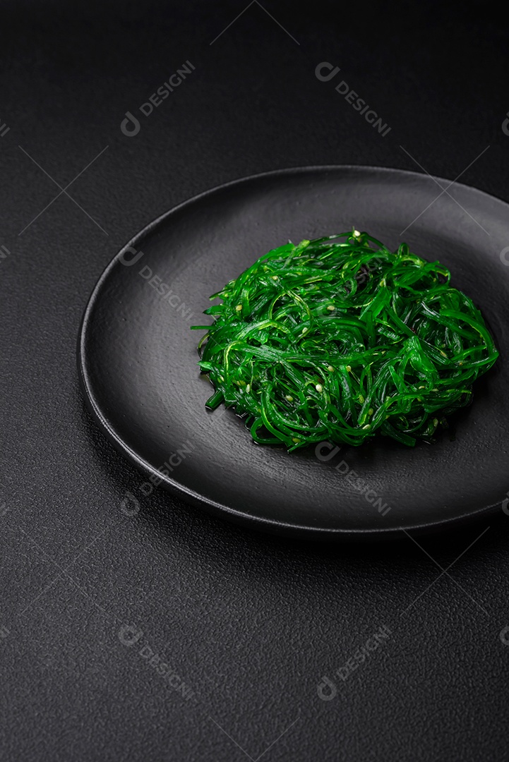 Deliciosa salada de frutos do mar hiashi wakume vegetariana saudável com sementes de gergelim em um fundo escuro de concreto