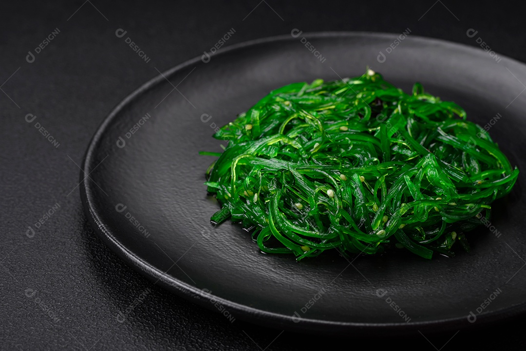 Deliciosa salada de frutos do mar hiashi wakume vegetariana saudável com sementes de gergelim em um fundo escuro de concreto