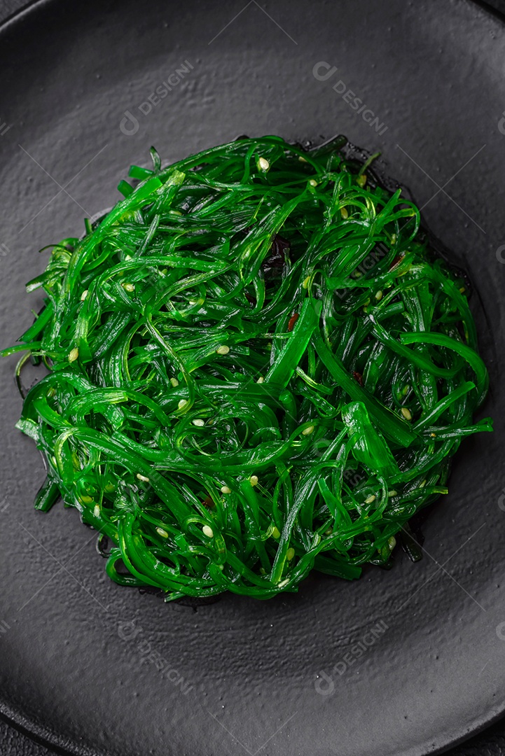 Deliciosa salada de frutos do mar hiashi wakume vegetariana saudável com sementes de gergelim em um fundo escuro de concreto