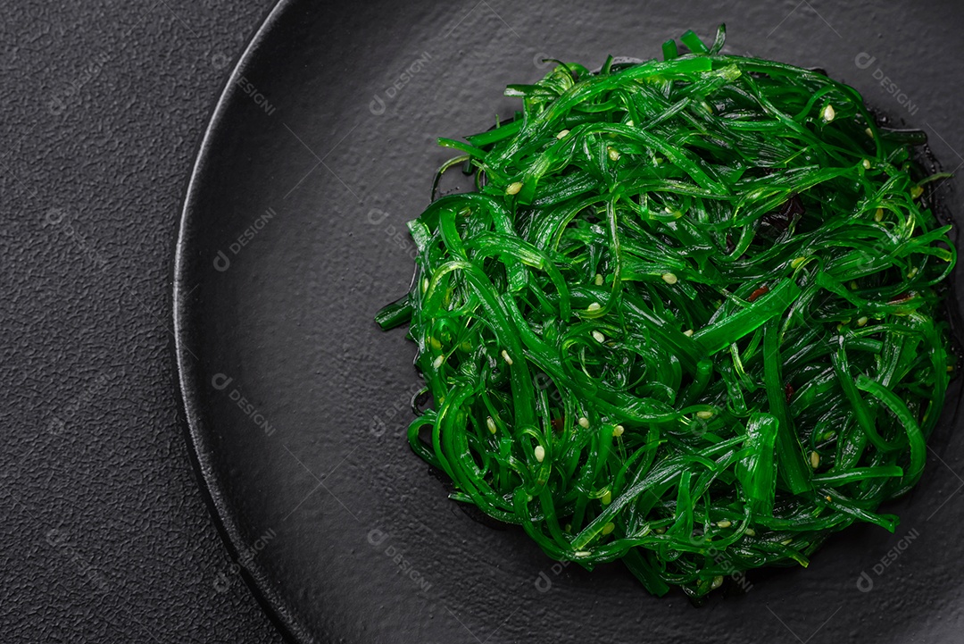 Deliciosa salada de frutos do mar hiashi wakume vegetariana saudável com sementes de gergelim em um fundo escuro de concreto