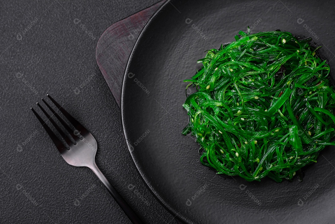 Deliciosa salada de frutos do mar hiashi wakume vegetariana saudável com sementes de gergelim em um fundo escuro de concreto