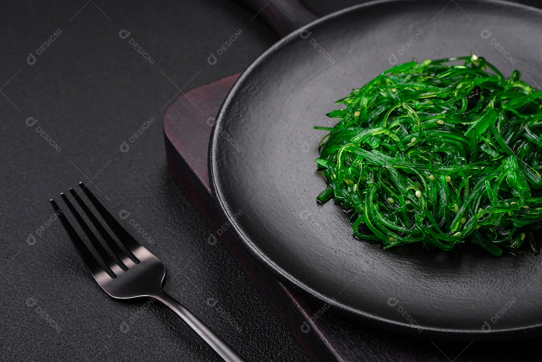 Deliciosa salada de frutos do mar hiashi wakume vegetariana saudável com sementes de gergelim em um fundo escuro de concreto