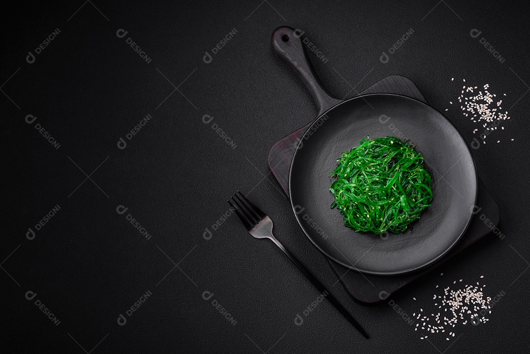 Deliciosa salada de frutos do mar hiashi wakume vegetariana saudável com sementes de gergelim em um fundo escuro de concreto