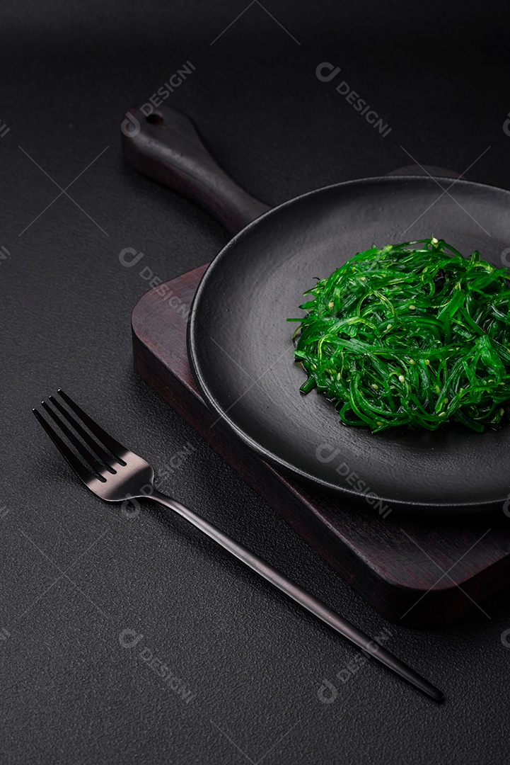 Deliciosa salada de frutos do mar hiashi wakume vegetariana saudável com sementes de gergelim em um fundo escuro de concreto