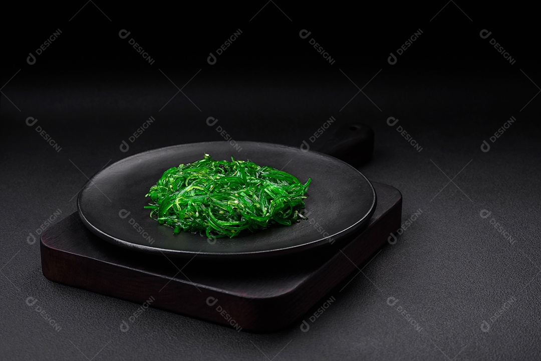 Deliciosa salada de frutos do mar hiashi wakume vegetariana saudável com sementes de gergelim em um fundo escuro de concreto