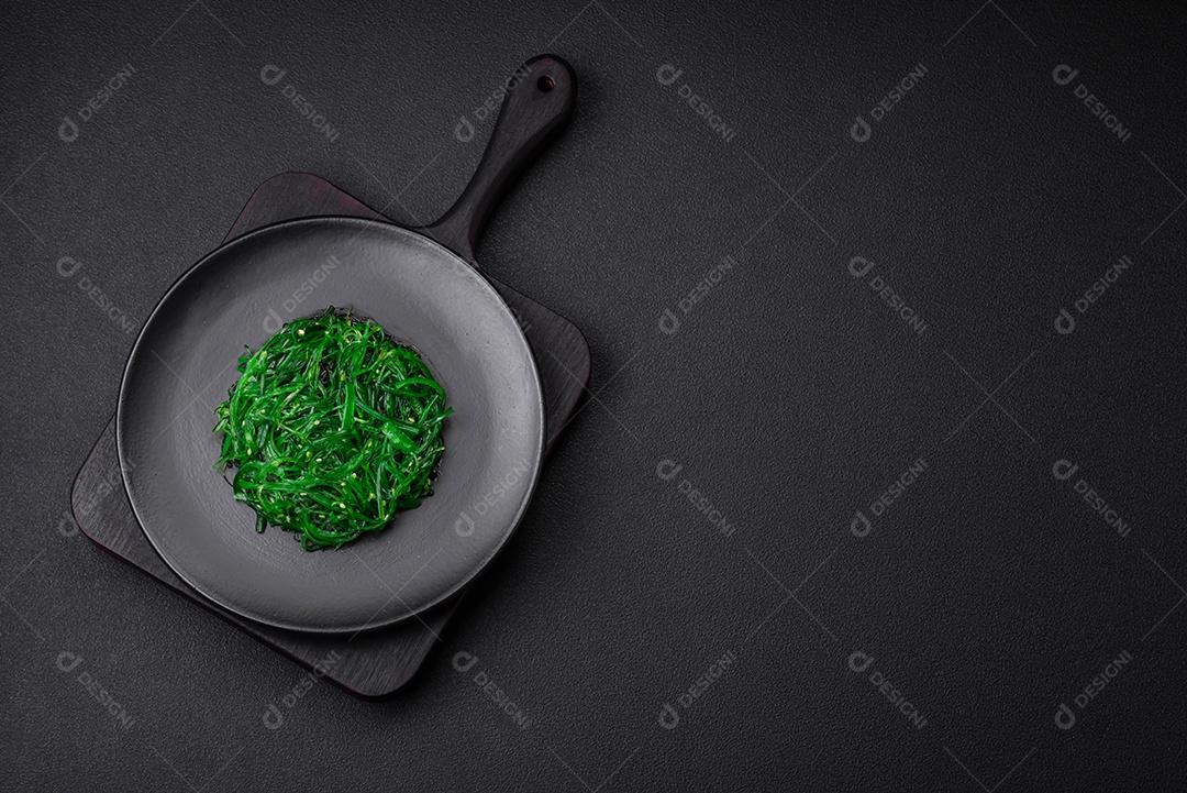 Deliciosa salada de frutos do mar hiashi wakume vegetariana saudável com sementes de gergelim em um fundo escuro de concreto