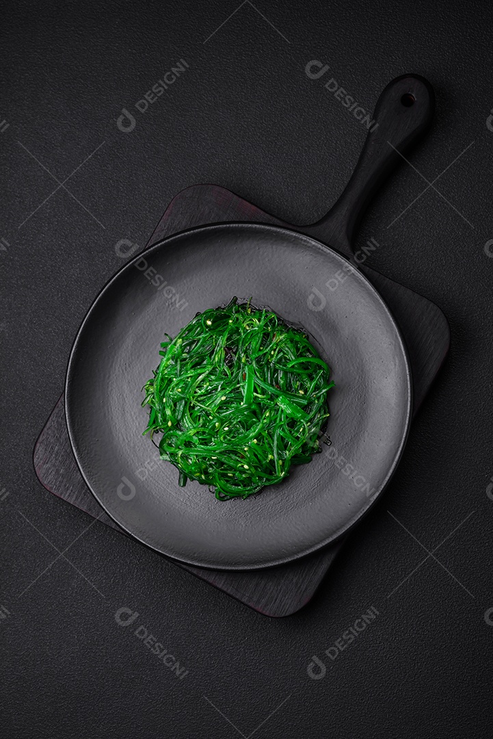 Deliciosa salada de frutos do mar hiashi wakume vegetariana saudável com sementes de gergelim em um fundo escuro de concreto