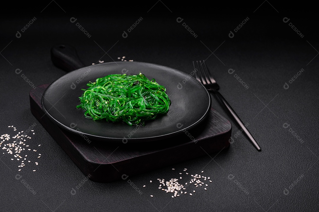 Deliciosa salada de frutos do mar hiashi wakume vegetariana saudável com sementes de gergelim em um fundo escuro de concreto