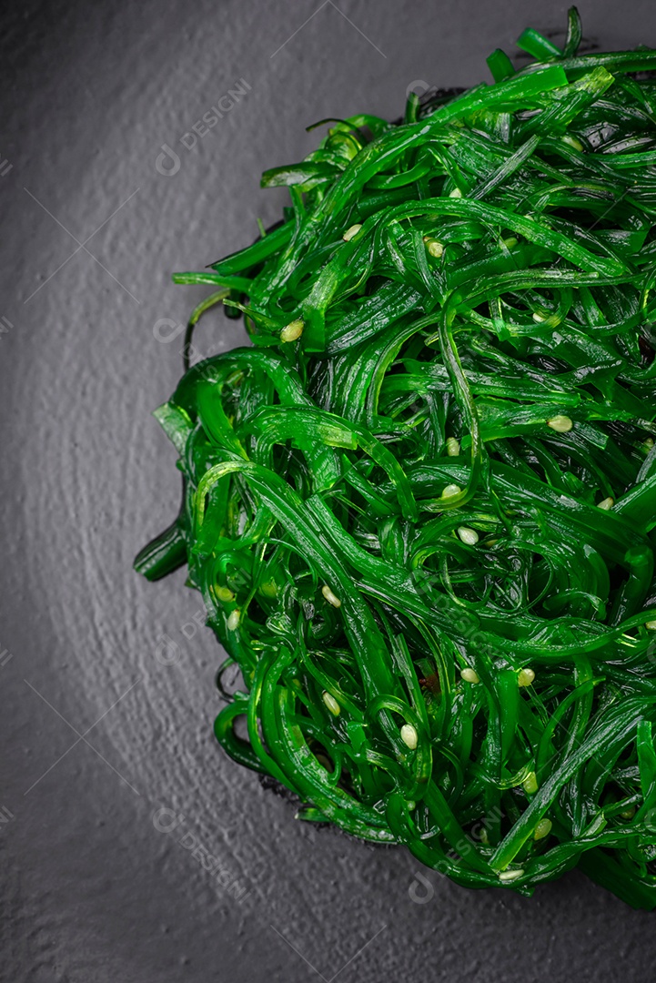 Deliciosa salada de frutos do mar hiashi wakume vegetariana saudável com sementes de gergelim em um fundo escuro de concreto