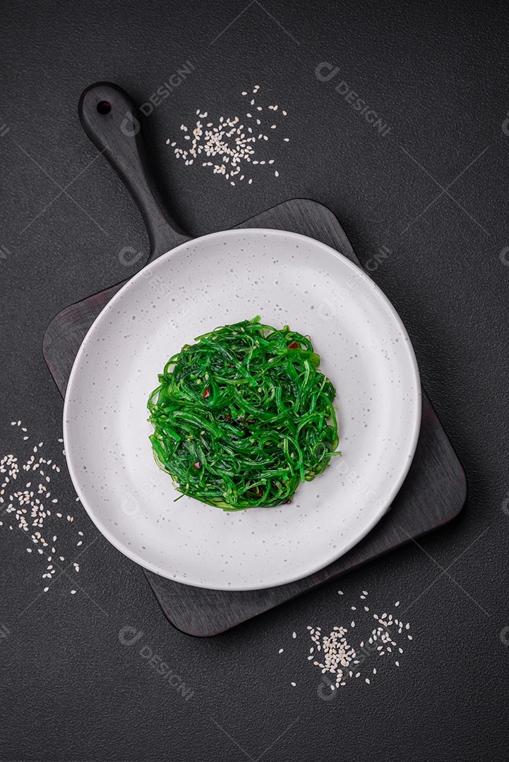 Deliciosa salada de frutos do mar hiashi wakume vegetariana saudável com sementes de gergelim em um fundo escuro de concreto