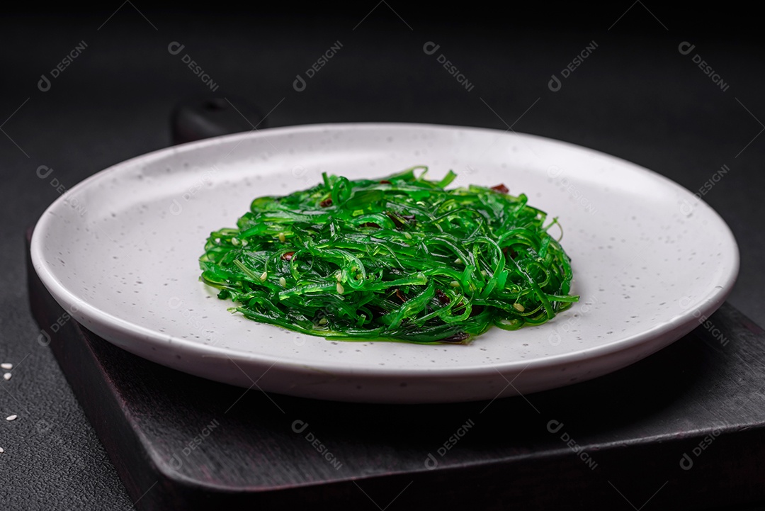 Deliciosa salada de frutos do mar hiashi wakume vegetariana saudável com sementes de gergelim em um fundo escuro de concreto