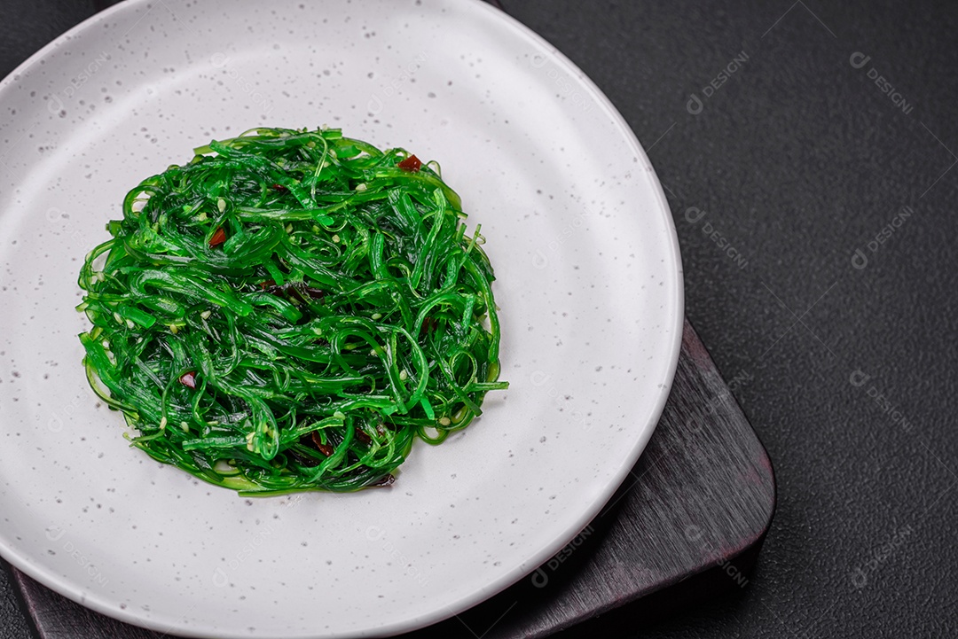 Deliciosa salada de frutos do mar hiashi wakume vegetariana saudável com sementes de gergelim em um fundo escuro de concreto