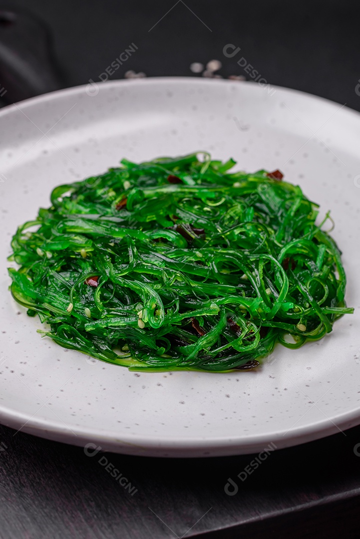 Deliciosa salada de frutos do mar hiashi wakume vegetariana saudável com sementes de gergelim em um fundo escuro de concreto