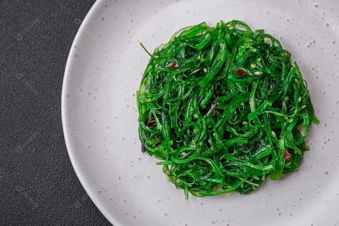 Deliciosa salada de frutos do mar hiashi wakume vegetariana saudável com sementes de gergelim em um fundo escuro de concreto
