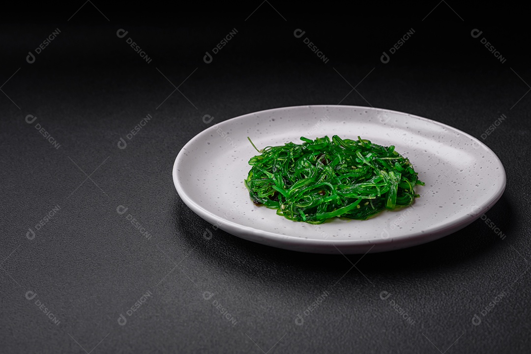 Deliciosa salada de frutos do mar hiashi wakume vegetariana saudável com sementes de gergelim em um fundo escuro de concreto
