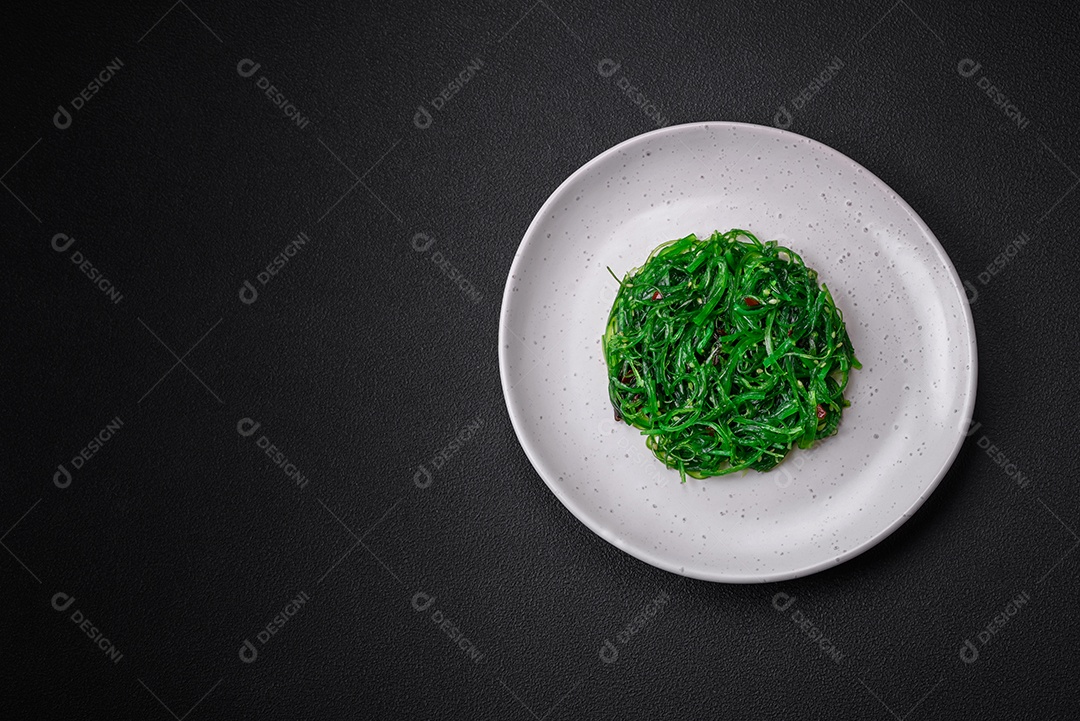 Deliciosa salada de frutos do mar hiashi wakume vegetariana saudável com sementes de gergelim em um fundo escuro de concreto