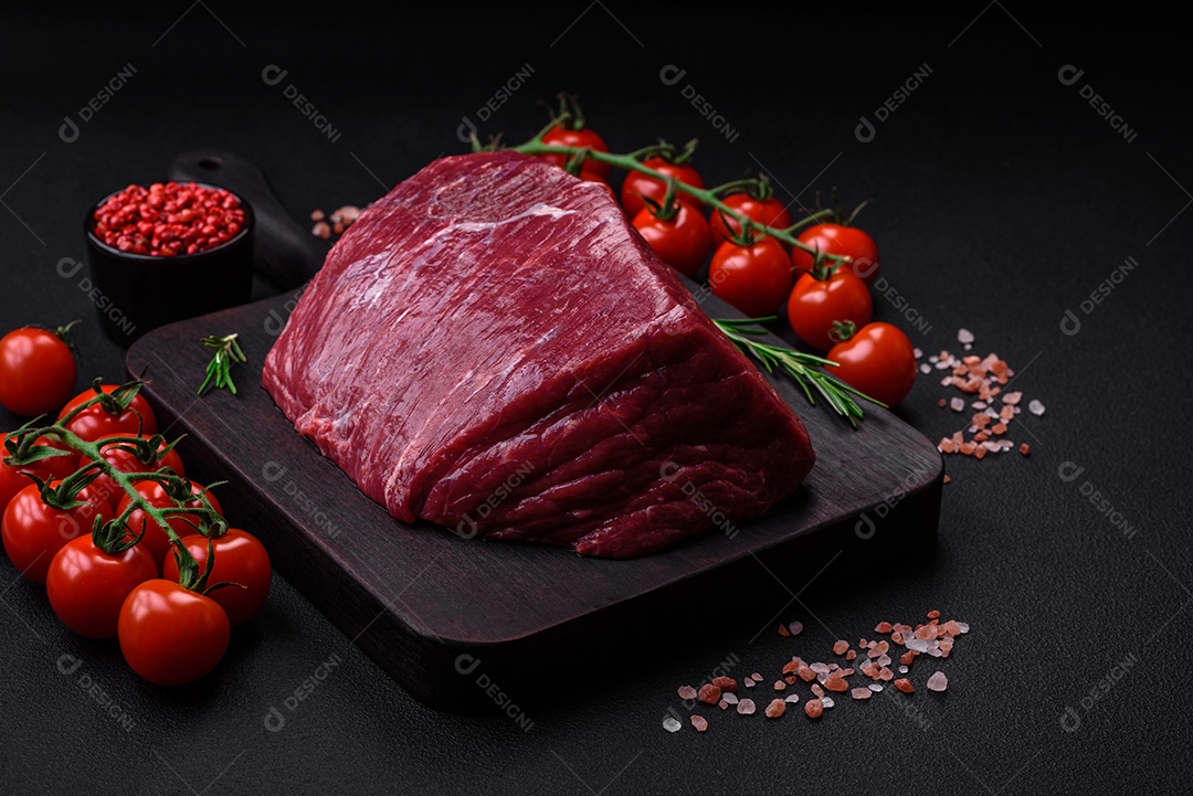 Carne de porco crua com osso ou costela cortada com sal, especiarias e ervas sobre um fundo escuro de concreto