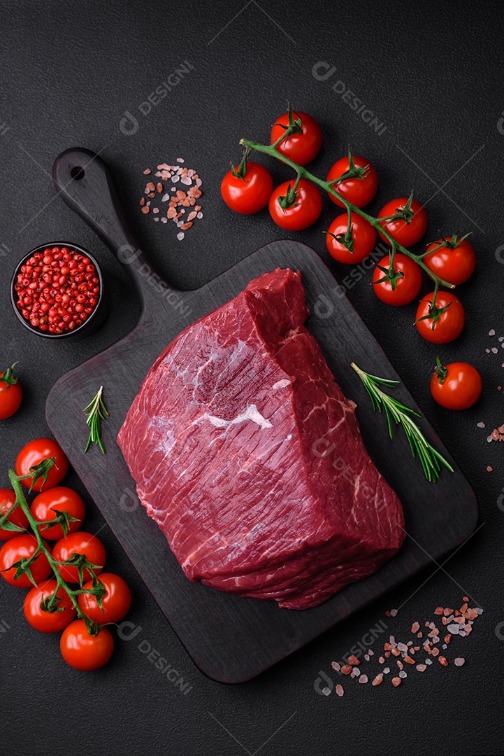 Carne de porco crua com osso ou costela cortada com sal, especiarias e ervas sobre um fundo escuro de concreto