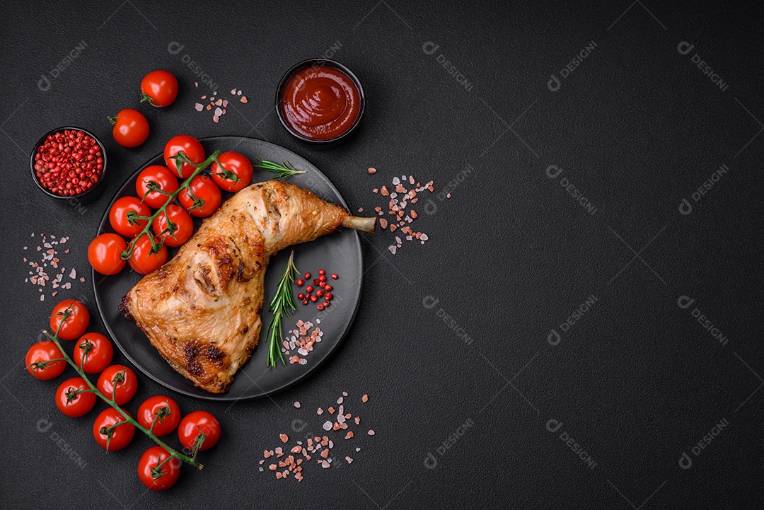 Perna de frango grelhado fresco com sal, especiarias e ervas sobre um fundo escuro de concreto