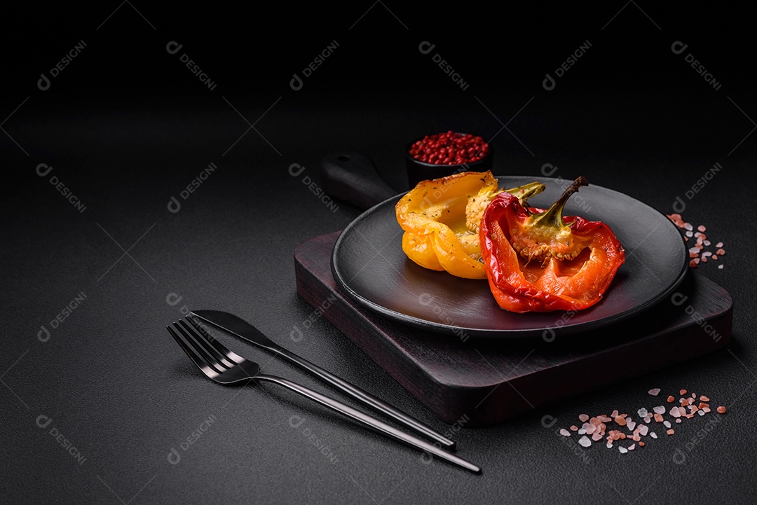 Deliciosos pimentões grelhados com especiarias e ervas em um fundo escuro de concreto