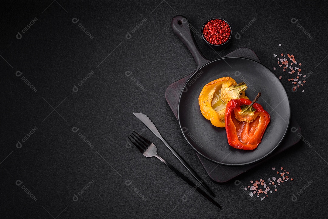 Deliciosos pimentões grelhados com especiarias e ervas em um fundo escuro de concreto