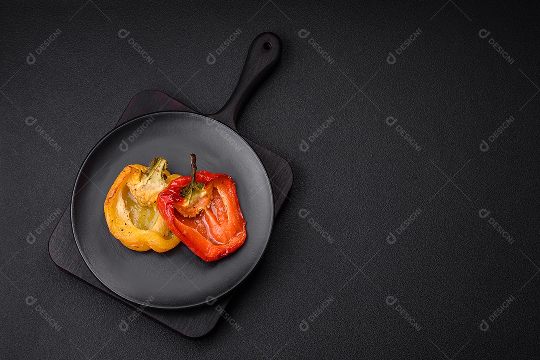 Deliciosos pimentões grelhados com especiarias e ervas em um fundo escuro de concreto