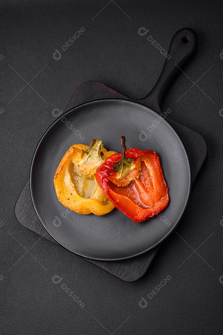 Deliciosos pimentões grelhados com especiarias e ervas em um fundo escuro de concreto