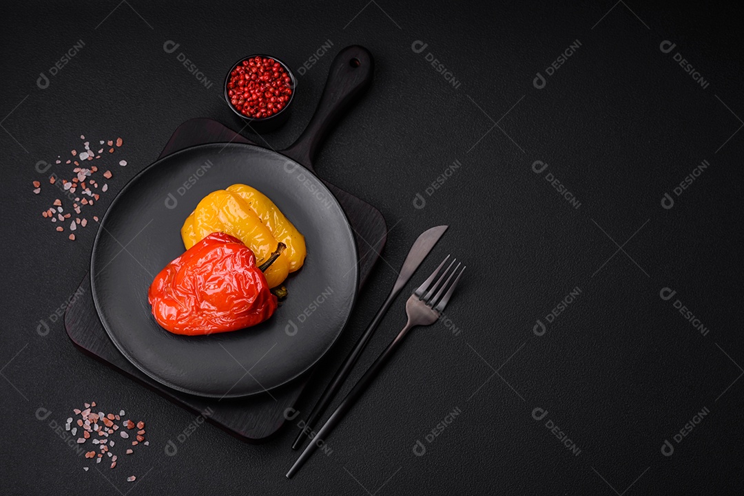 Deliciosos pimentões grelhados com especiarias e ervas em um fundo escuro de concreto