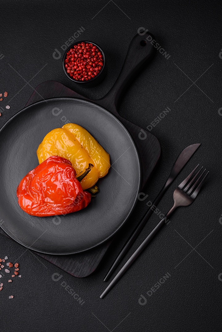 Deliciosos pimentões grelhados com especiarias e ervas em um fundo escuro de concreto