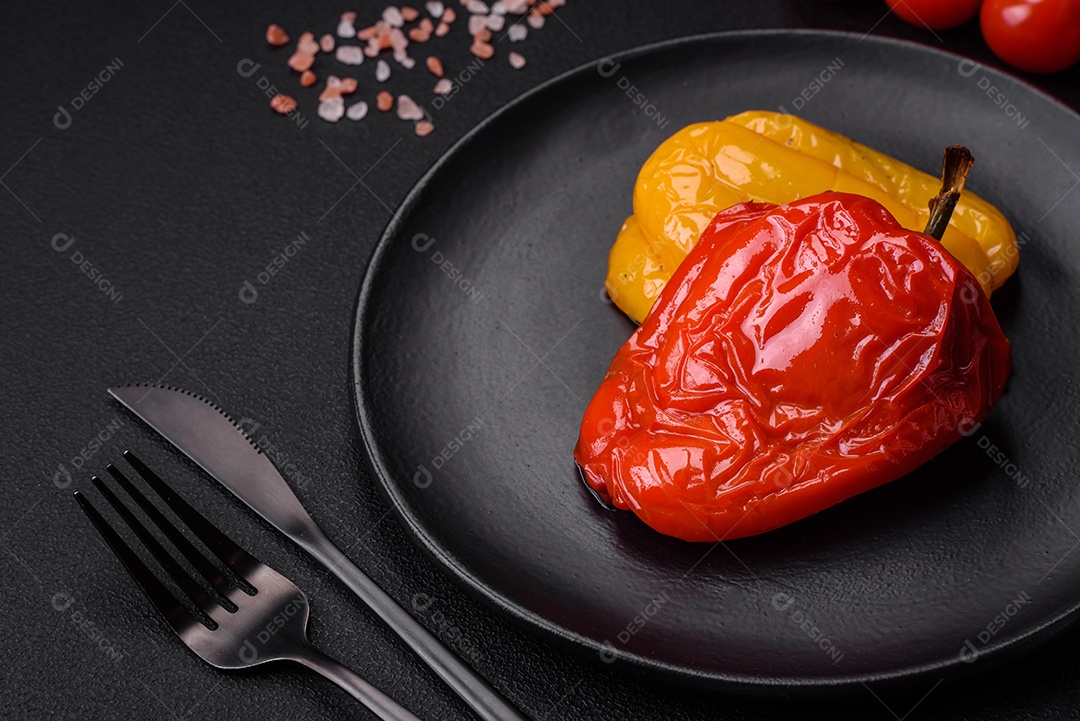 Deliciosos pimentões grelhados com especiarias e ervas em um fundo escuro de concreto