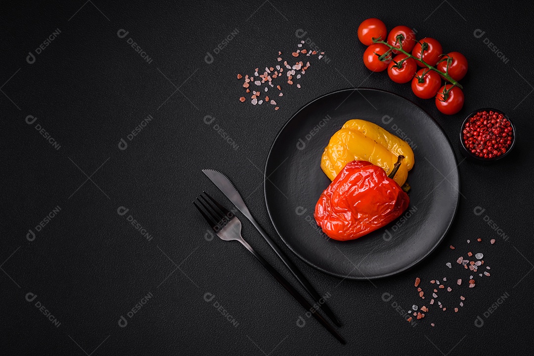 Deliciosos pimentões grelhados com especiarias e ervas em um fundo escuro de concreto