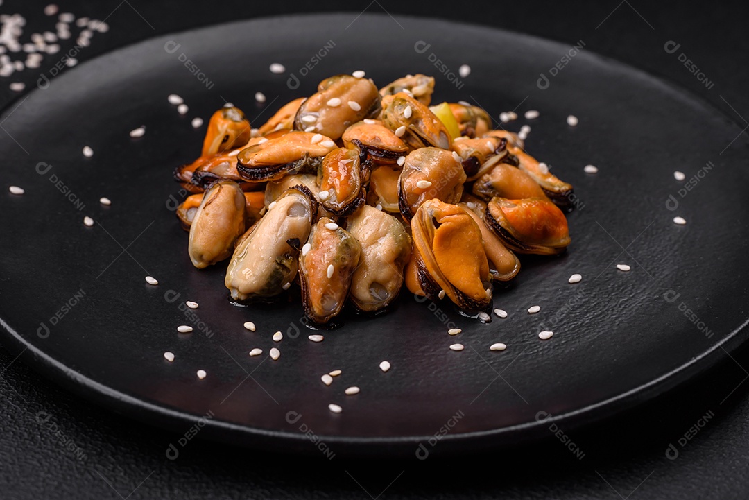 Deliciosos mexilhões marinados com especiarias e ervas em uma placa cerâmica sobre um fundo escuro de concreto