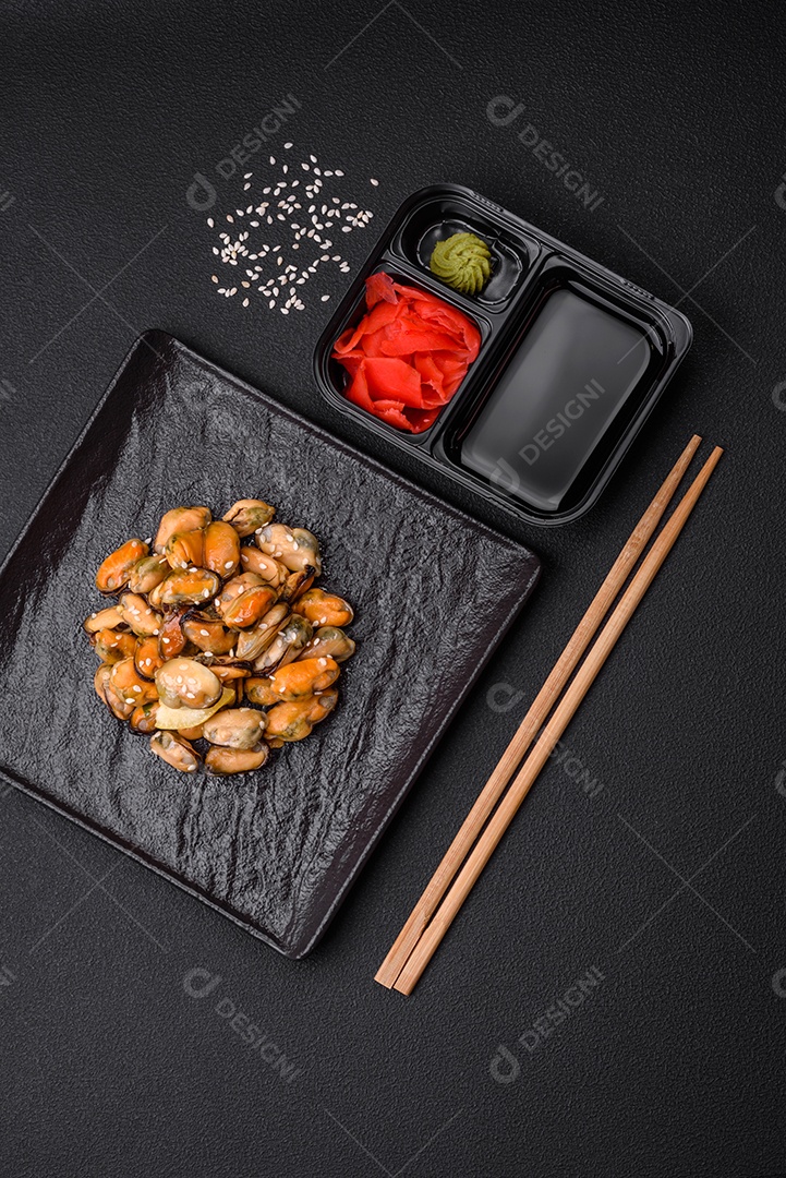 Gengibre em conserva, molho de soja e wasabi em recipientes de plástico porcionados sobre um fundo escuro de concreto