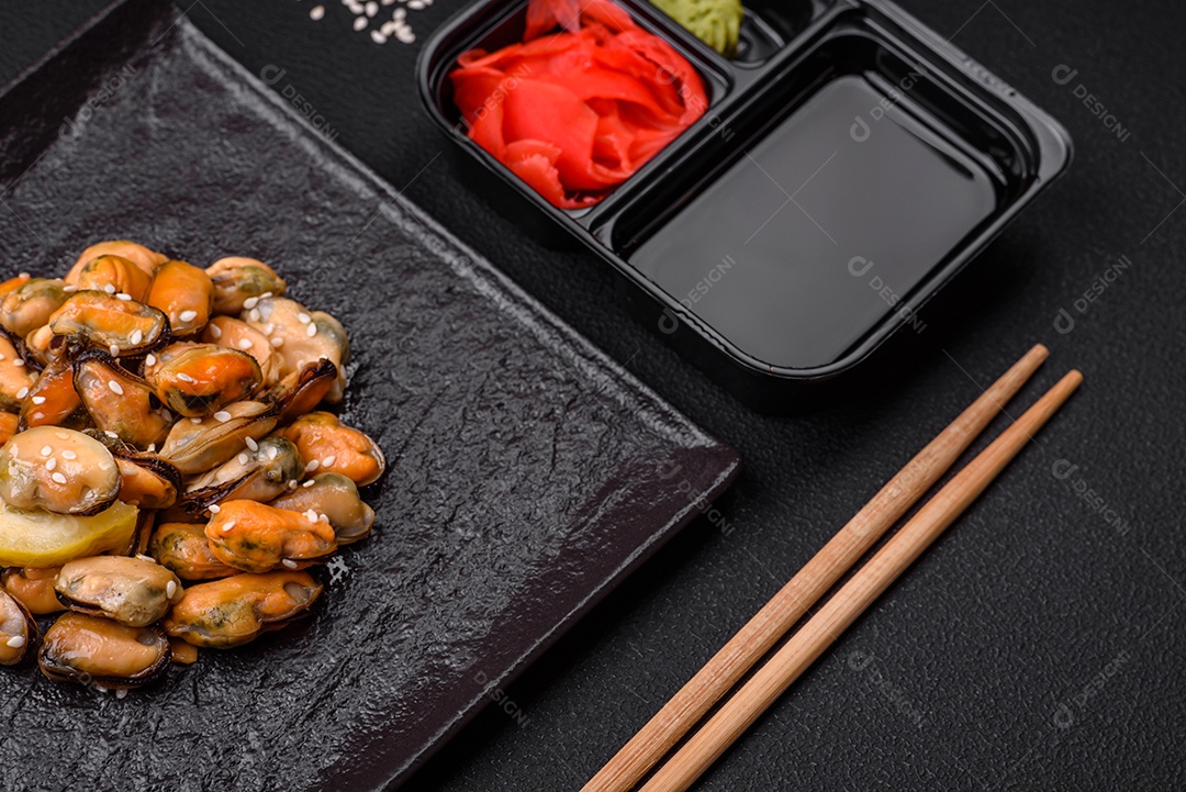 Gengibre em conserva, molho de soja e wasabi em recipientes de plástico porcionados sobre um fundo escuro de concreto