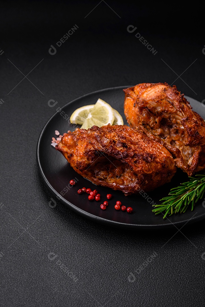 Delicioso robalo frito em forma de fatias com especiarias e ervas em uma placa cerâmica sobre um fundo escuro de concreto