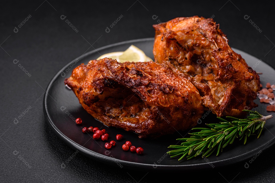 Delicioso robalo frito em forma de fatias com especiarias e ervas em uma placa cerâmica sobre um fundo escuro de concreto