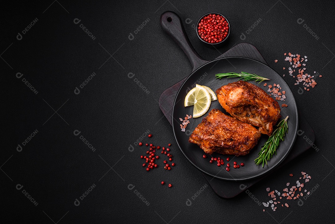 Delicioso robalo frito em forma de fatias com especiarias e ervas em uma placa cerâmica sobre um fundo escuro de concreto