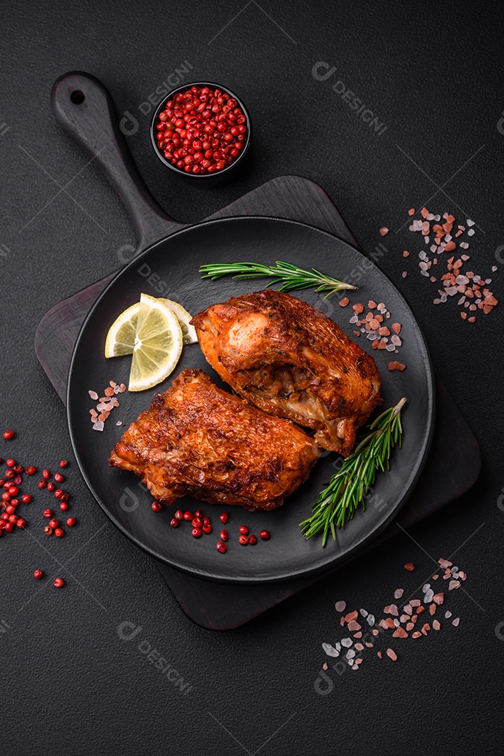 Delicioso robalo frito em forma de fatias com especiarias e ervas em uma placa cerâmica sobre um fundo escuro de concreto