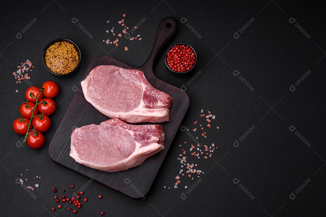 Carne de porco crua com osso ou costela cortada com sal, especiarias e ervas sobre um fundo escuro de concreto