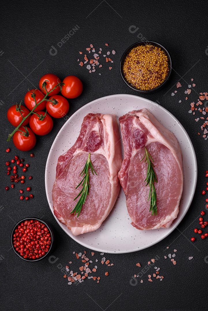 Carne de porco crua com osso ou costela cortada com sal, especiarias e ervas sobre um fundo escuro de concreto