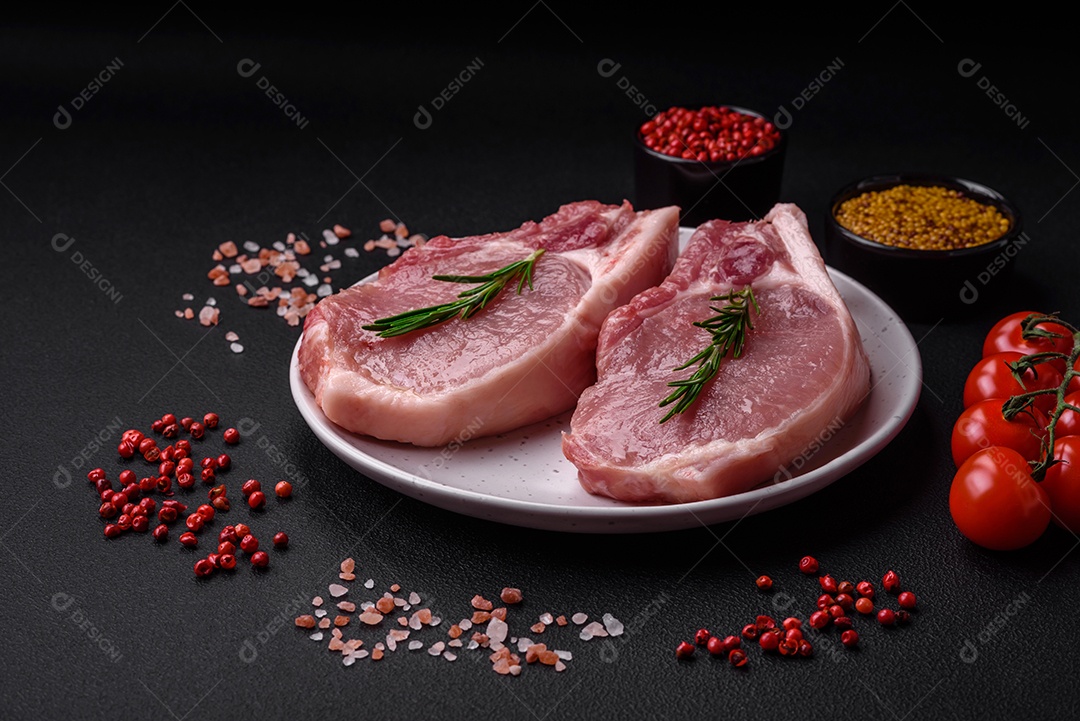 Carne de porco crua com osso ou costela cortada com sal, especiarias e ervas sobre um fundo escuro de concreto
