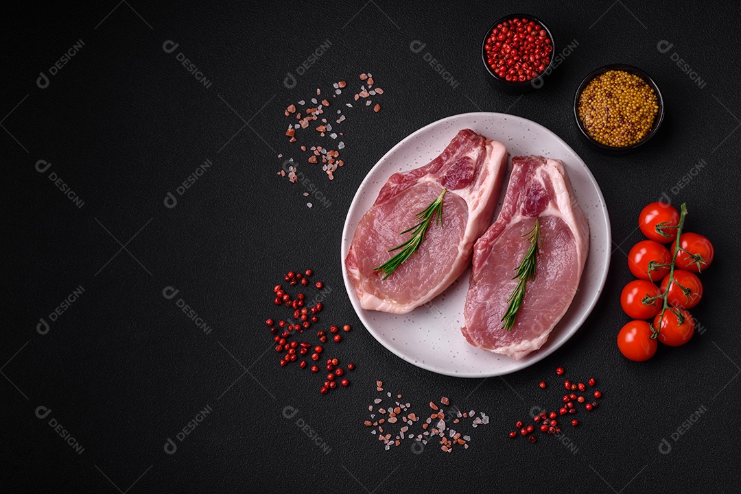 Carne de porco crua com osso ou costela cortada com sal, especiarias e ervas sobre um fundo escuro de concreto