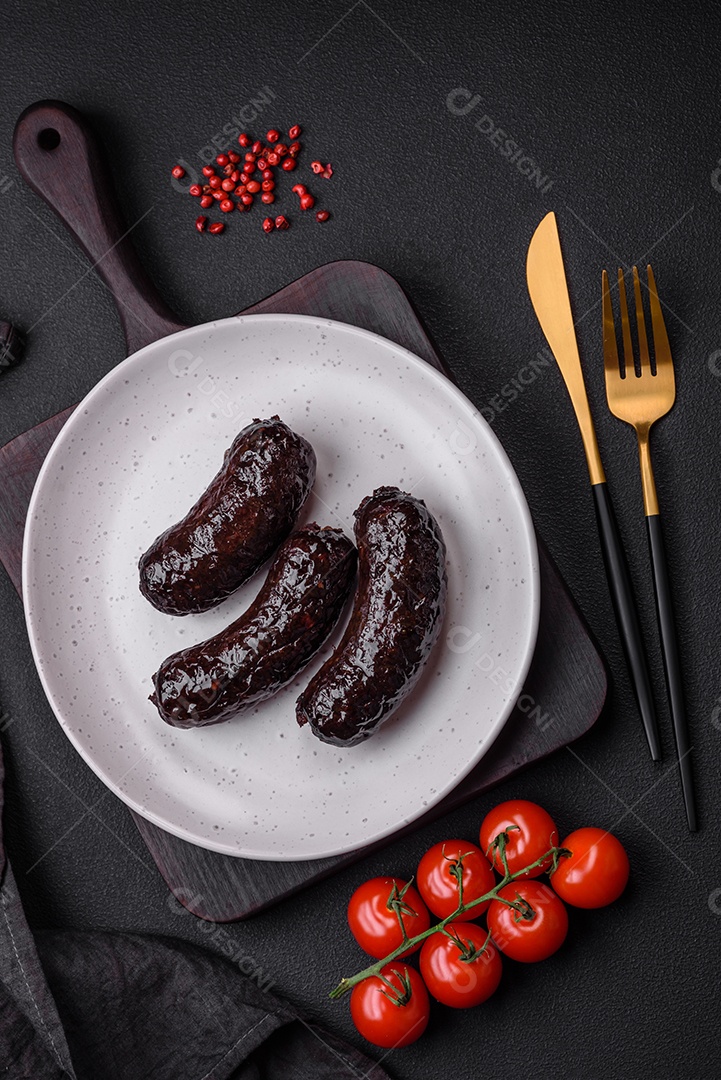 Delicioso chouriço preto ou morcela com especiarias e ervas grelhadas sobre fundo de concreto preto