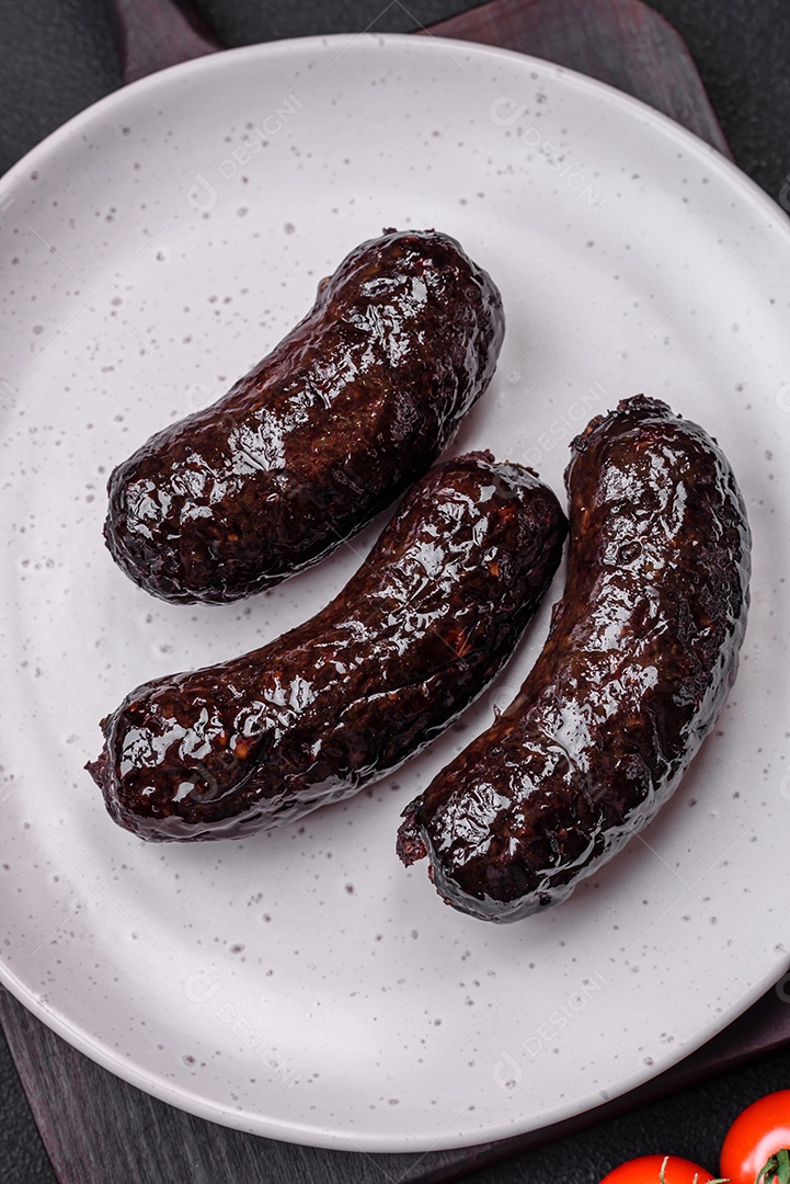 Delicioso chouriço preto ou morcela com especiarias e ervas grelhadas sobre fundo de concreto preto